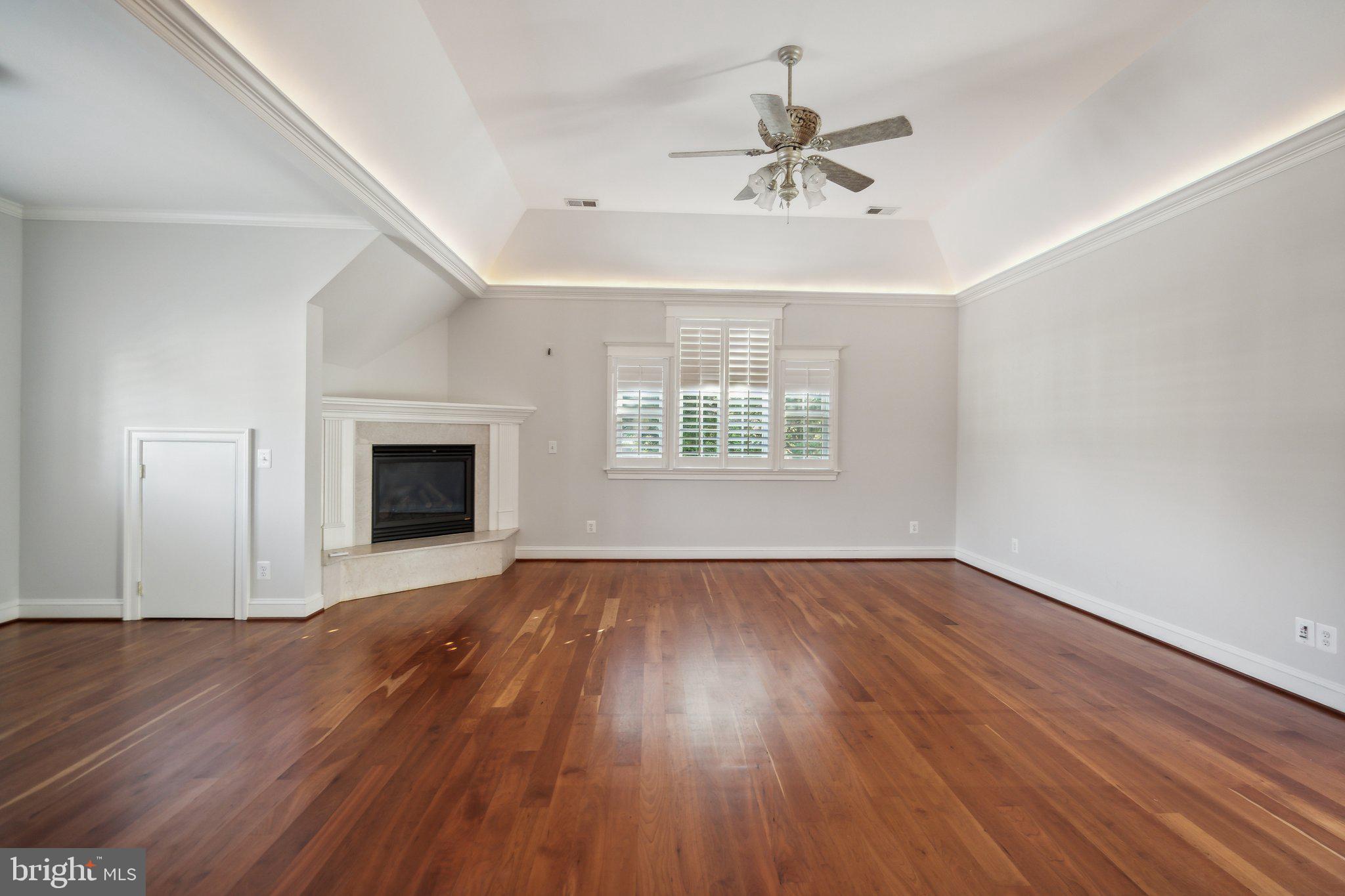 8802 Northern Spruce Lane Alexandria, VA 22309 - Photo 20 of 41 an empty room with wooden floor fan and windows