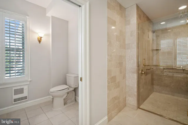 a bathroom with a granite countertop sink a toilet and a shower