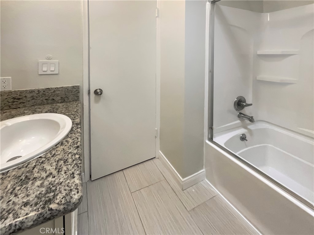 14560 Clark Street, Unit 202 Sherman Oaks, CA 91411 - Photo 11 of 18 a bathroom with a granite countertop sink and a bathtub
