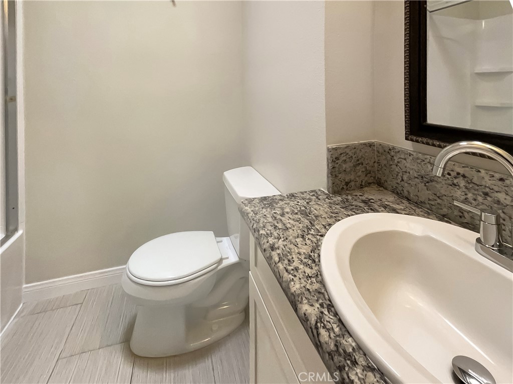 14560 Clark Street, Unit 202 Sherman Oaks, CA 91411 - Photo 12 of 18 a bathroom with a granite countertop sink and a mirror