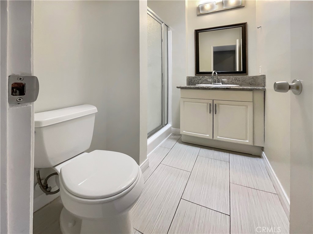 14560 Clark Street, Unit 202 Sherman Oaks, CA 91411 - Photo 13 of 18 a bathroom with a toilet a sink a vanity and mirror