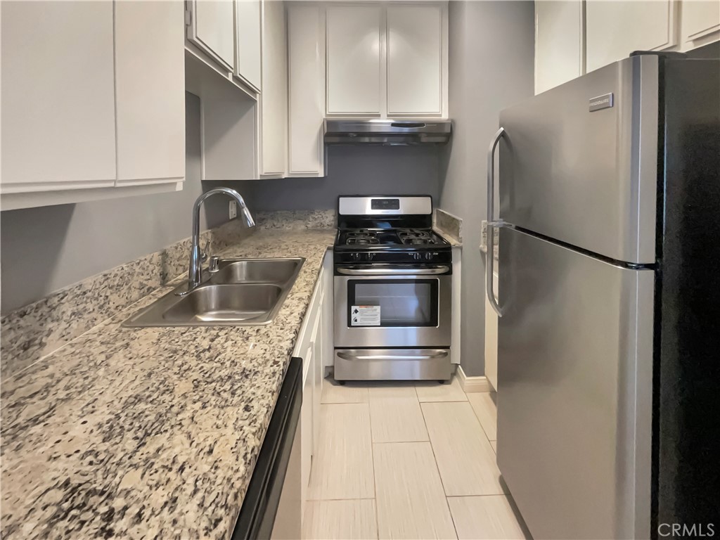 14560 Clark Street, Unit 202 Sherman Oaks, CA 91411 - Photo 4 of 18 a kitchen with stainless steel appliances granite countertop a refrigerator and a sink