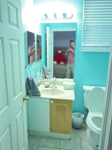 a bathroom with a toilet sink and mirror