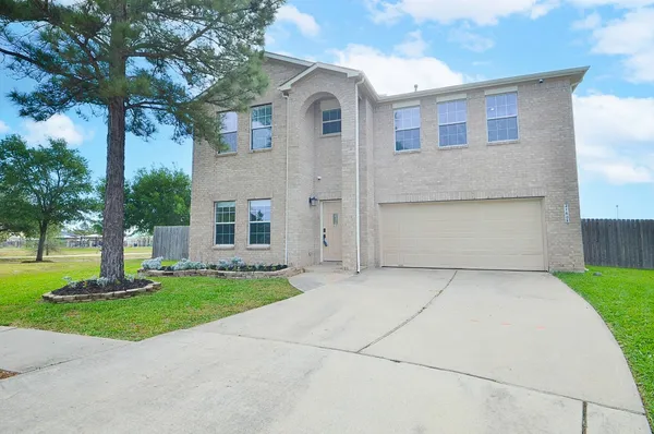 a front view of a house with a yard and trees