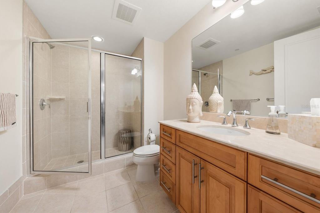 331 Cleveland Street, Unit 301 Clearwater, FL 33755 - Photo 25 of 39 a bathroom with a double vanity sink toilet and shower