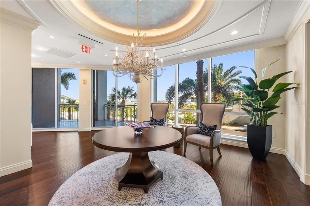 331 Cleveland Street, Unit 301 Clearwater, FL 33755 - Photo 31 of 39 a living room with furniture a chandelier and a dining table with wooden floor