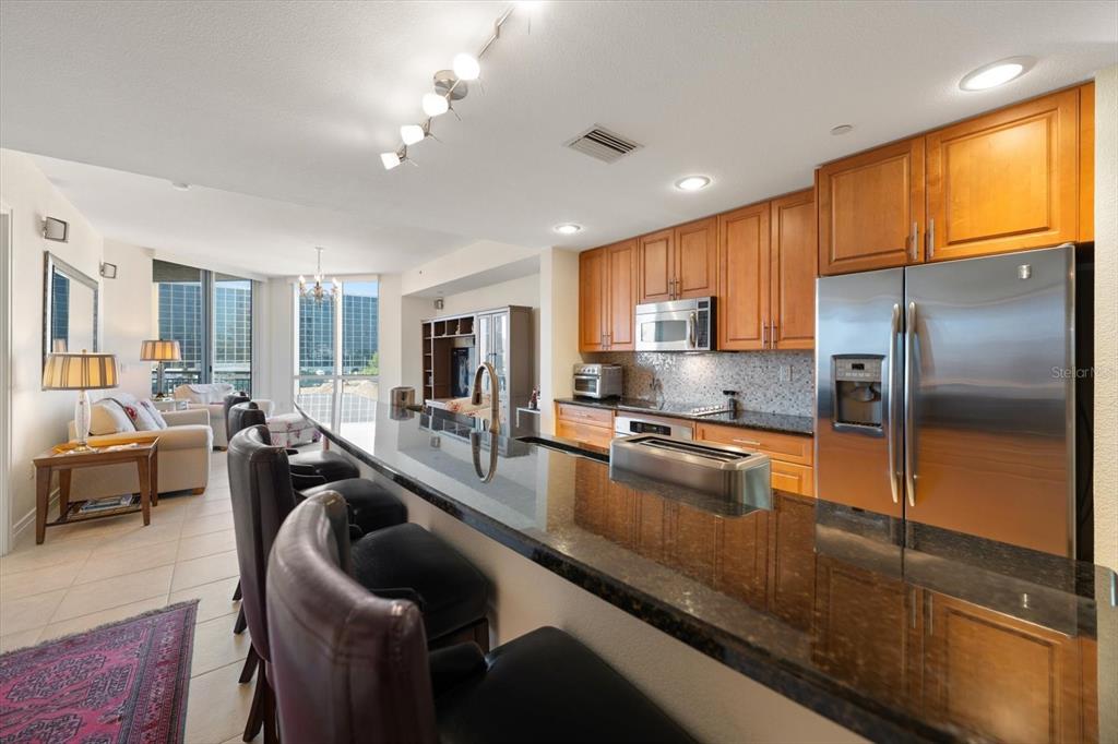 331 Cleveland Street, Unit 301 Clearwater, FL 33755 - Photo 7 of 39 a large kitchen with kitchen island granite countertop a large counter top appliances and cabinets
