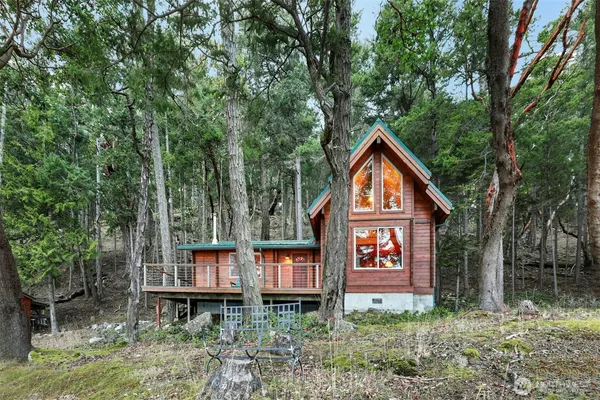 a front view of a house with balcony and trees