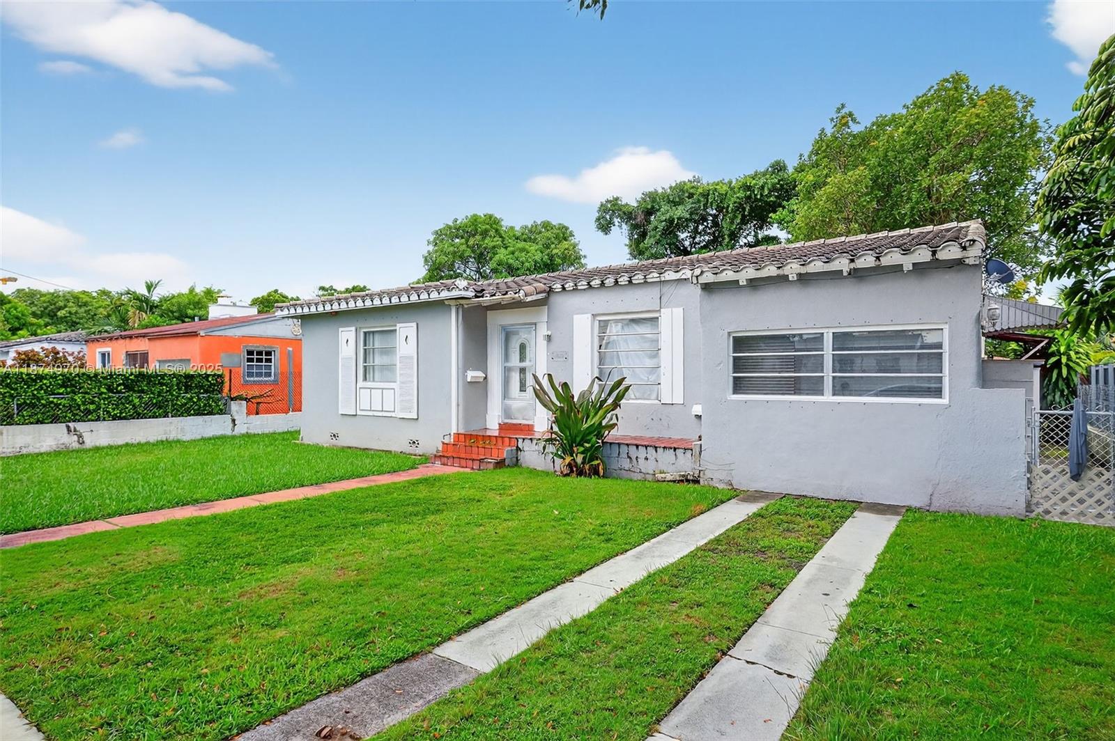 2850 Northwest 4th Street Miami, FL 33125 - Photo 3 of 17 a front view of a house with a garden and yard