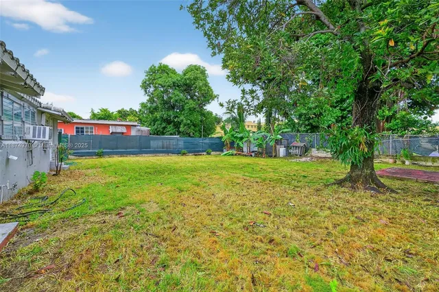 a view of a yard with a house in the background