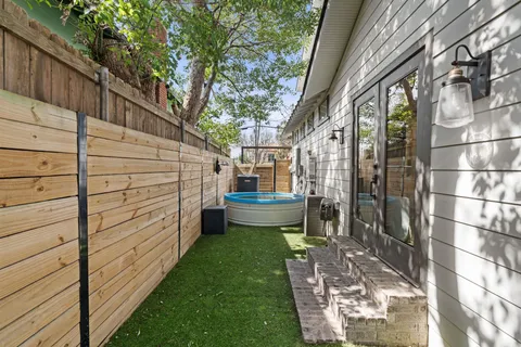 a view of a house with a small yard and wooden fence