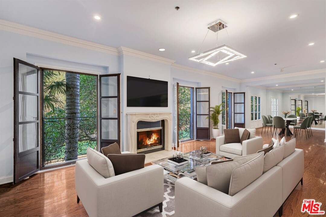 425 North Maple Drive, Unit 304 Beverly Hills, CA 90210 - Photo 4 of 26 a living room with furniture fireplace and a large window