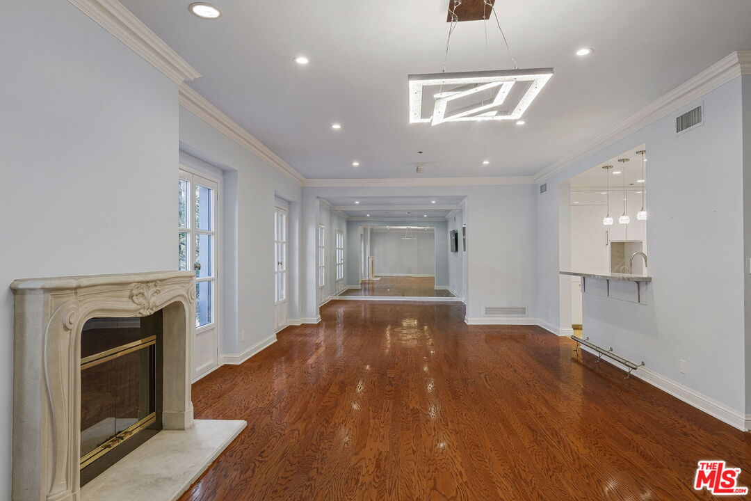 425 North Maple Drive, Unit 304 Beverly Hills, CA 90210 - Photo 8 of 26 a spacious bedroom with a bed and a fireplace