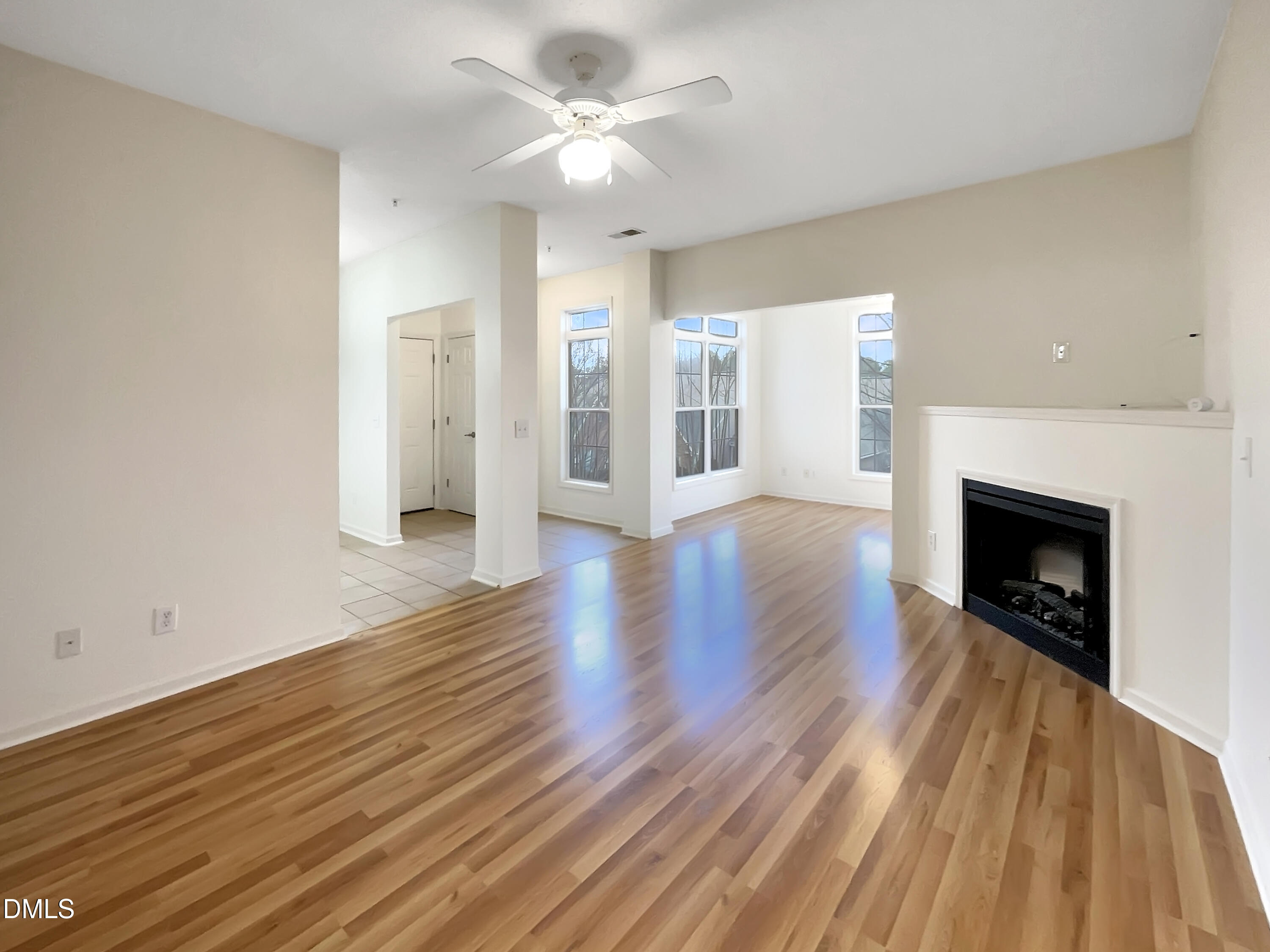 2501 Huntscroft Lane, Unit 203 Raleigh, NC 27617 - Photo 13 of 16 a view of an empty room with wooden floor fireplace and a window
