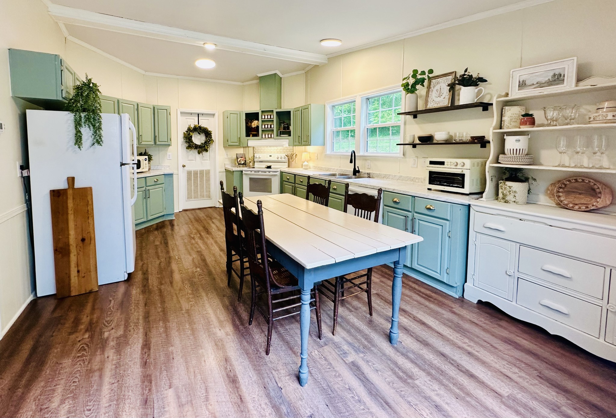 4002 Rippey Lake Road Mount Pleasant, TN 38474 - Photo 12 of 43 a kitchen with stainless steel appliances a dining table chairs and wooden floor