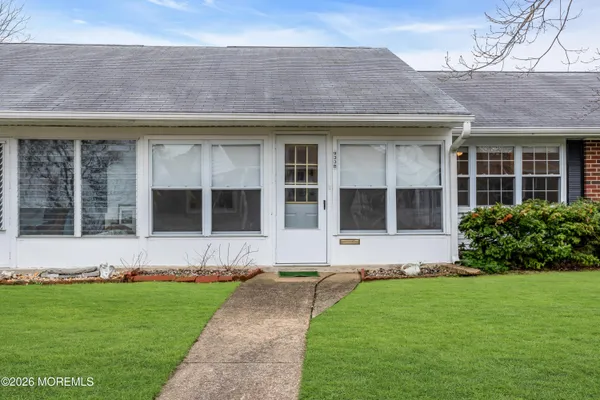a front view of a house with a garden and yard