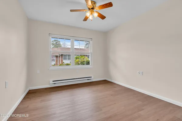 an empty room with window and wooden floor