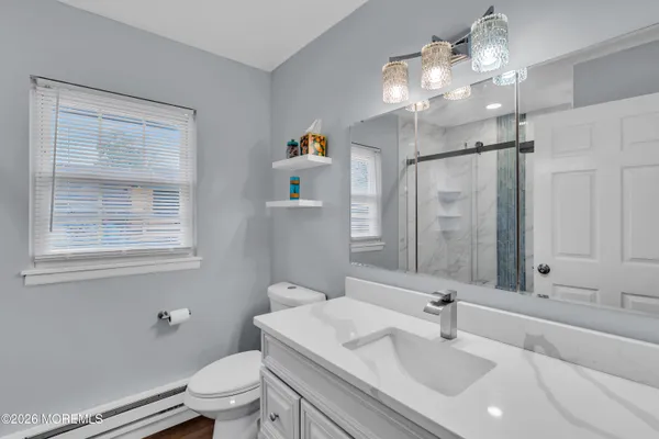 a bathroom with a sink a toilet and a mirror