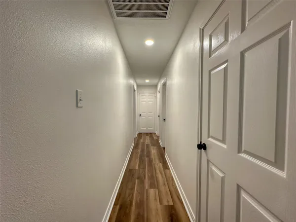 a view of a hallway with wooden floor and staircase