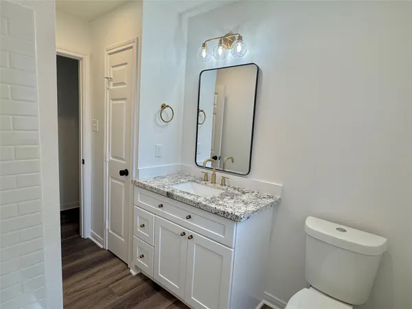 a bathroom with a toilet a sink and mirror
