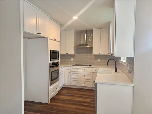 a kitchen with granite countertop white cabinets and white appliances