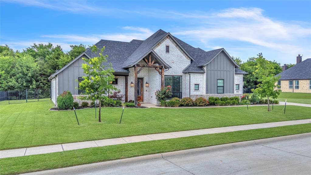 1014 Rennard Street Caddo Mills, TX 75135 - Photo 38 of 39 Modern farmhouse style exterior featuring brick, board & batten siding, and a stone exterior. Also shown is the covered front porch and elevated landscaping.
