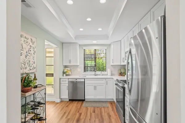 a kitchen with a sink a refrigerator and a window
