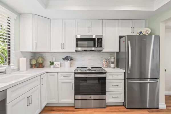 a kitchen with white cabinets and stainless steel appliances