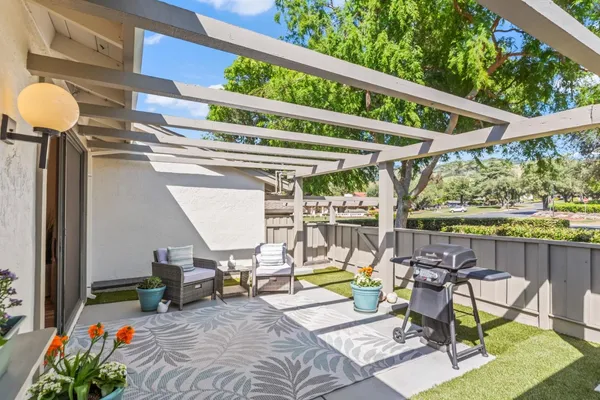 a view of a chairs and table in patio with swimming pool
