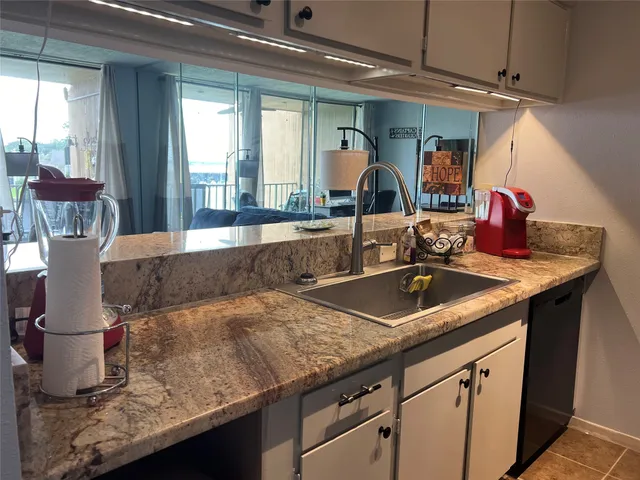a kitchen with granite countertop a sink and a window