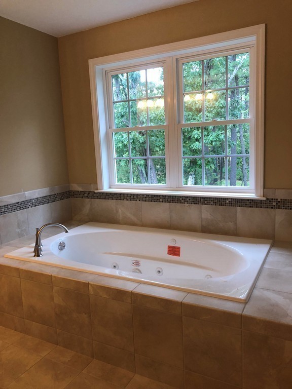 108 Robin Hill Road Groton, MA 01450 - Photo 16 of 24 a bath tub sitting in a bathroom next to a window
