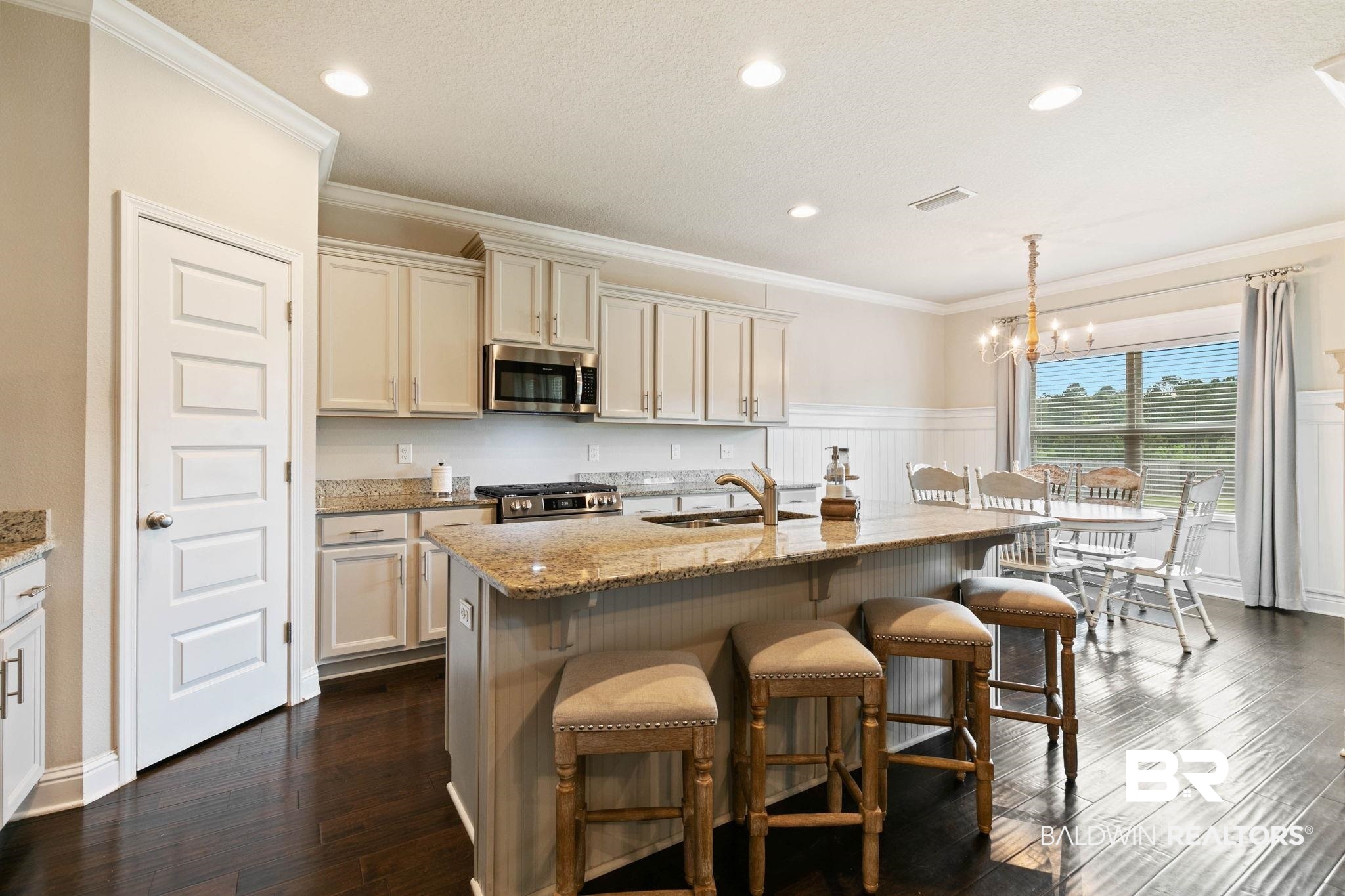 31187 Spoonbill Road Daphne, AL 36527 - Photo 14 of 85 Kitchen with wood-finish flooring, light-toned cabinetry, granite countertops, and stainless steel appliances
