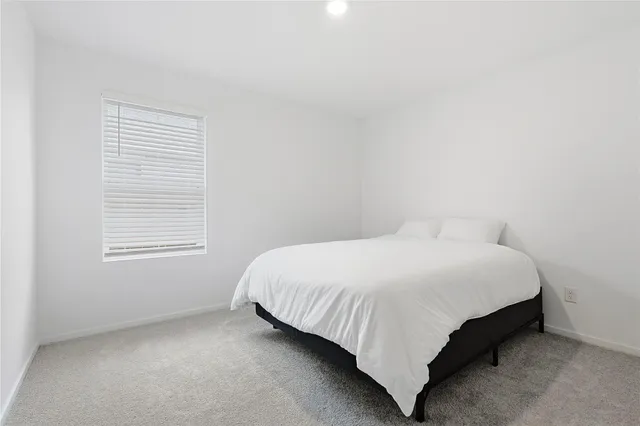 a bed sitting in a bedroom next to a window