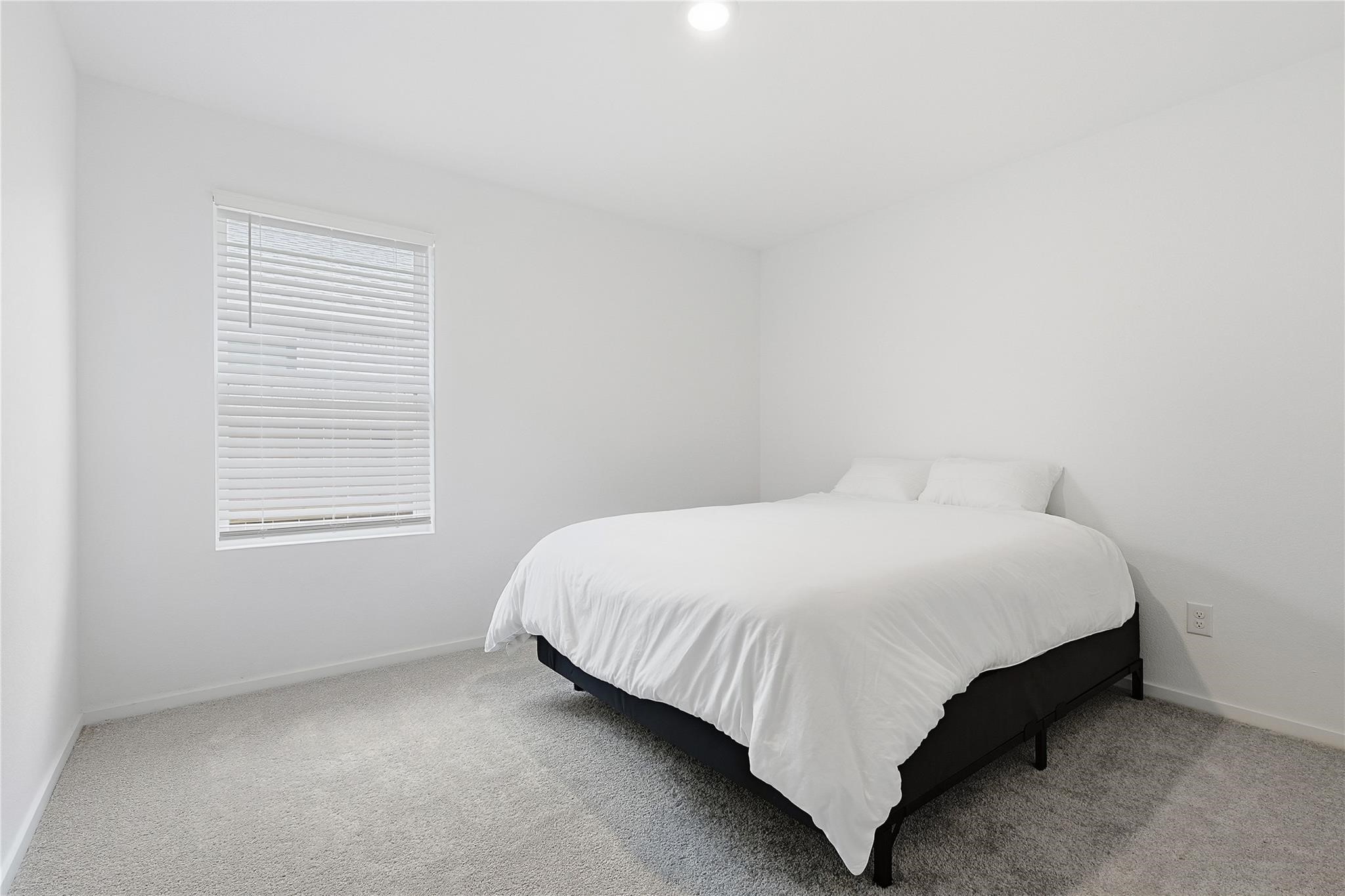 1135 Rustic Willow Drive Beasley, TX 77417 - Photo 13 of 20 a bed sitting in a bedroom next to a window