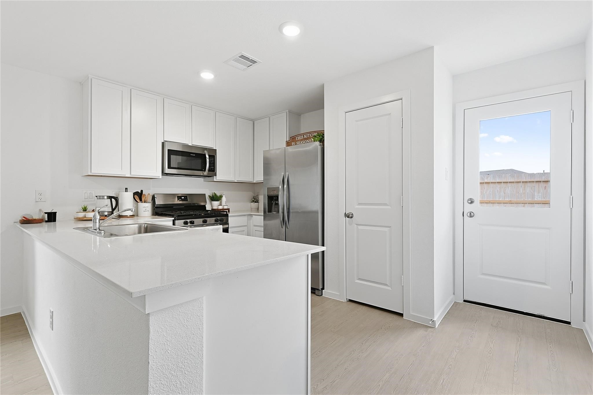 1135 Rustic Willow Drive Beasley, TX 77417 - Photo 6 of 20 a kitchen with kitchen island a refrigerator sink and white cabinets