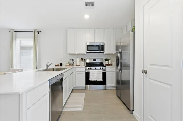 a kitchen with a sink cabinets and stainless steel appliances