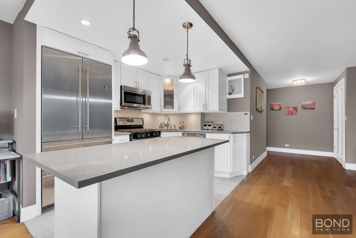 372 Central Park West, Unit 9K Manhattan, NY 10025 - Photo 2 of 8 a kitchen with kitchen island a sink stainless steel appliances and a window