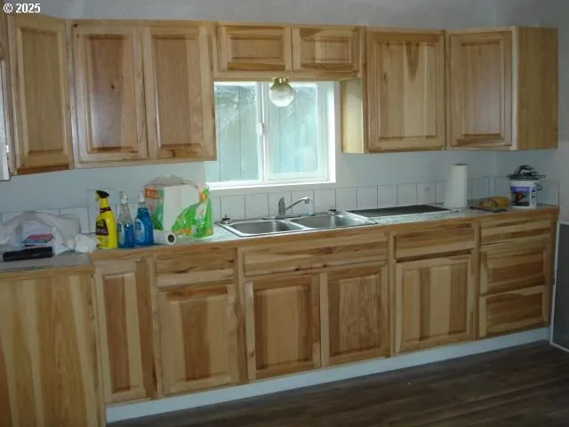 a kitchen with stainless steel appliances granite countertop a sink dishwasher and cabinets with wooden floor