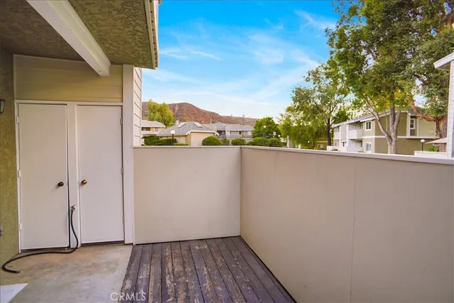 a view of a balcony with wooden floor and a large tree