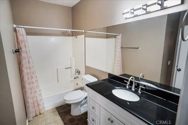 a bathroom with a granite countertop sink toilet a mirror a vanity and shower