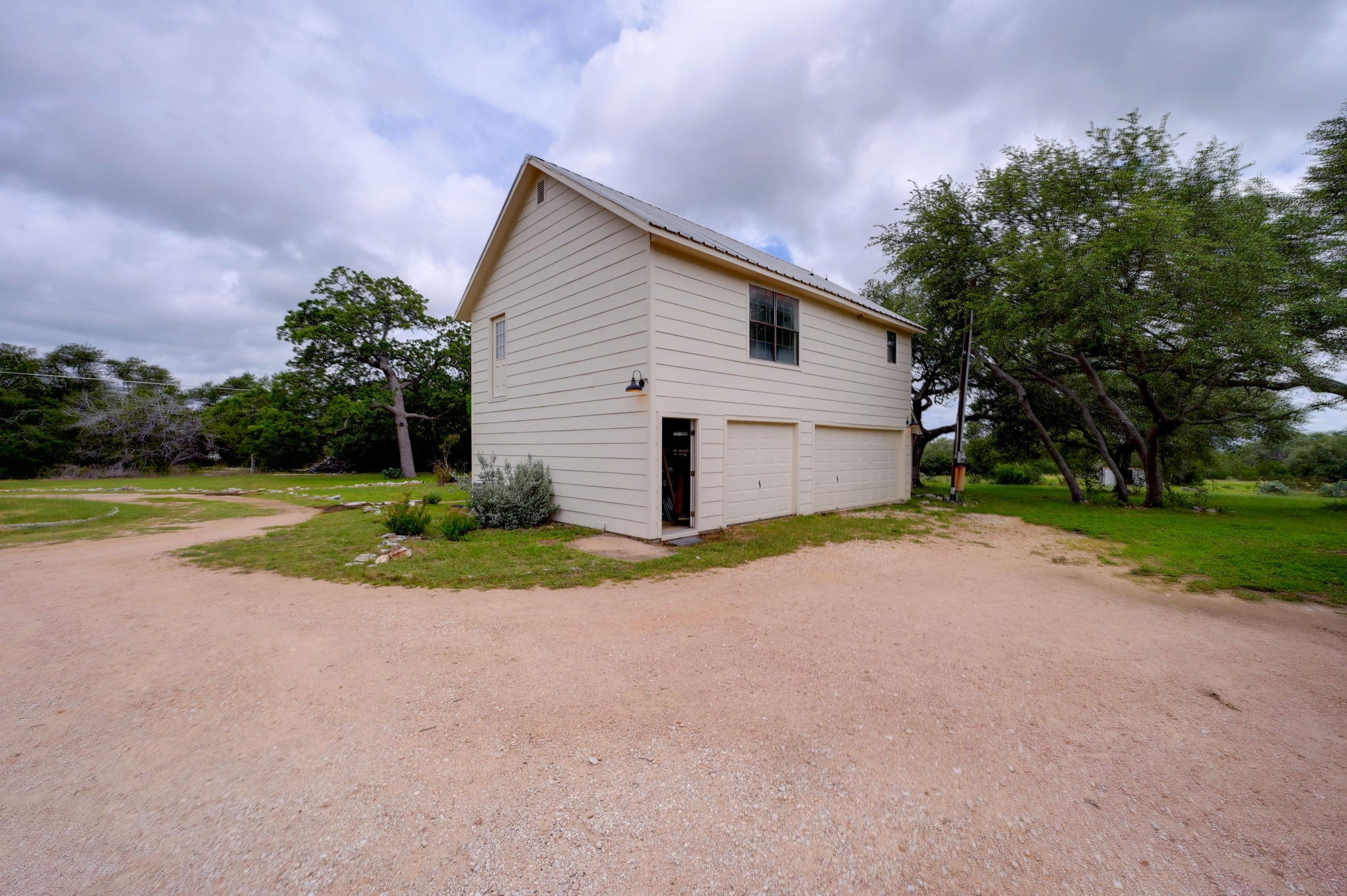 364 Nameless Road Driftwood, TX 78619 - Photo 25 of 32 Three-car garage with overhead living space provides flexible options for this property.