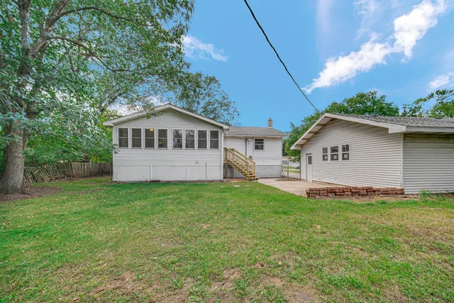 a view of a house with a yard and sitting area