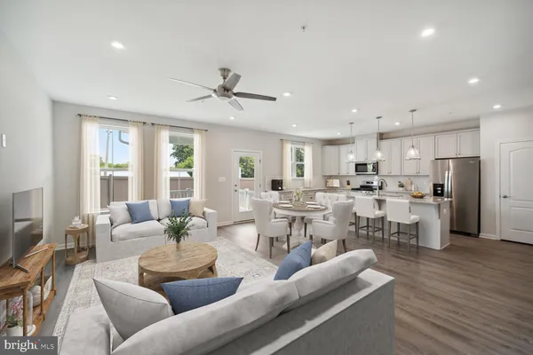 a living room with lots of furniture and view of kitchen