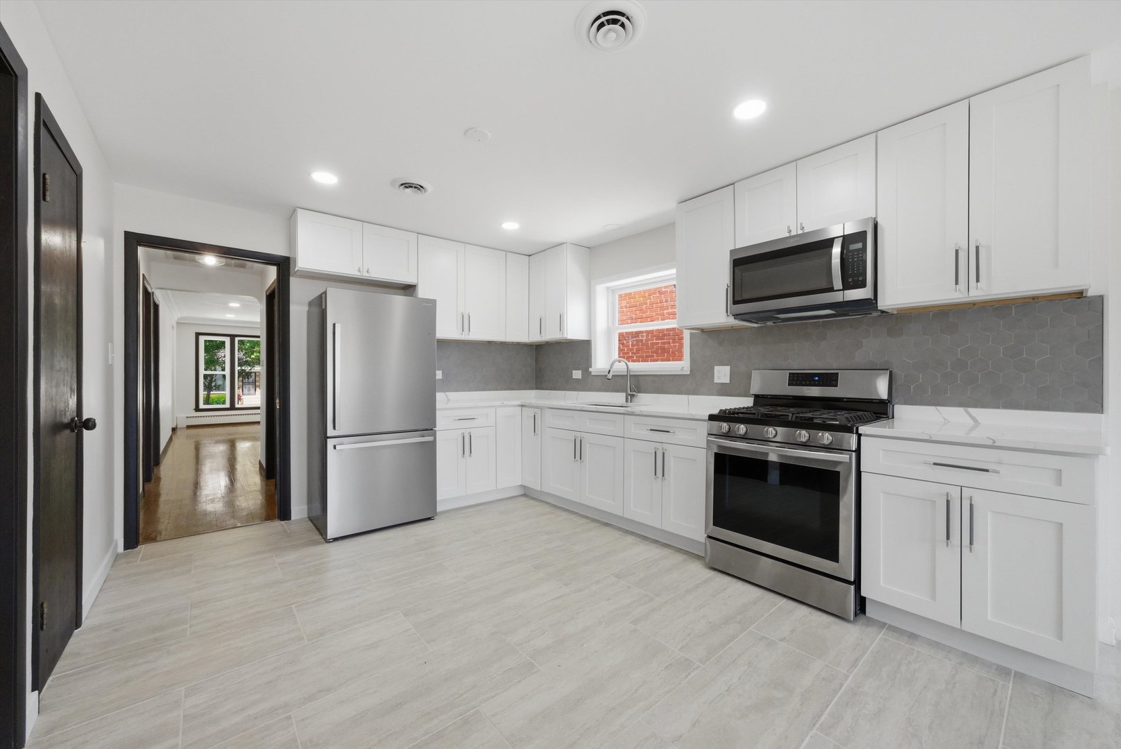 3907 West Marquette Road Chicago, IL 60629 - Photo 12 of 32 a kitchen with stainless steel appliances granite countertop a refrigerator stove a sink and a microwave