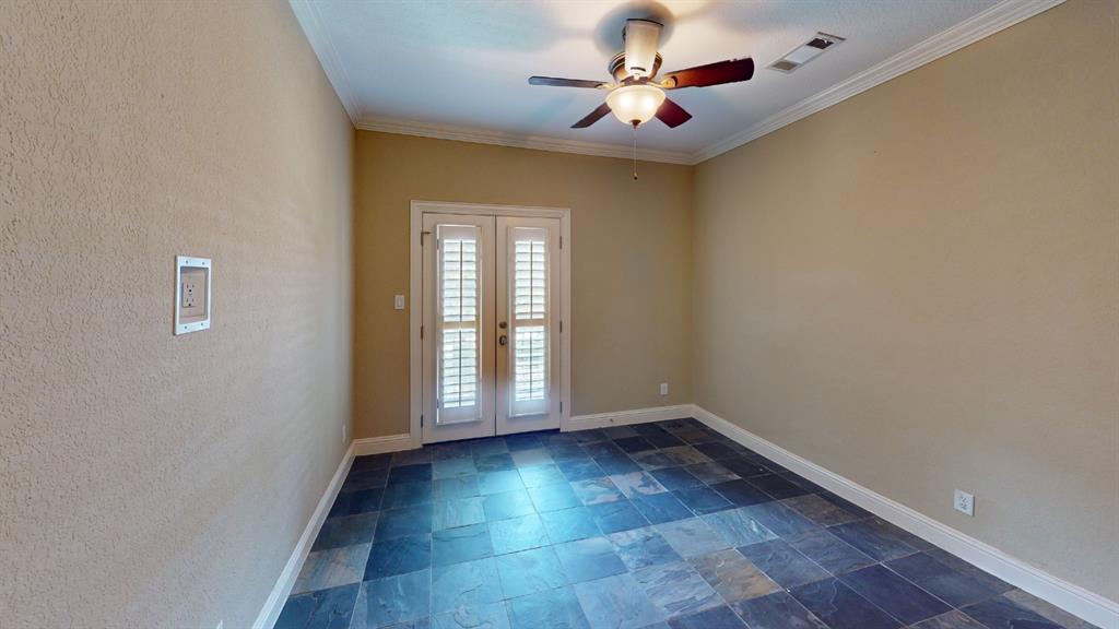 4516 Gilbert Avenue Dallas, TX 75219 - Photo 14 of 28 Room featuring slate tile flooring, neutral wall tones, crown molding, and a ceiling fan with integrated lighting