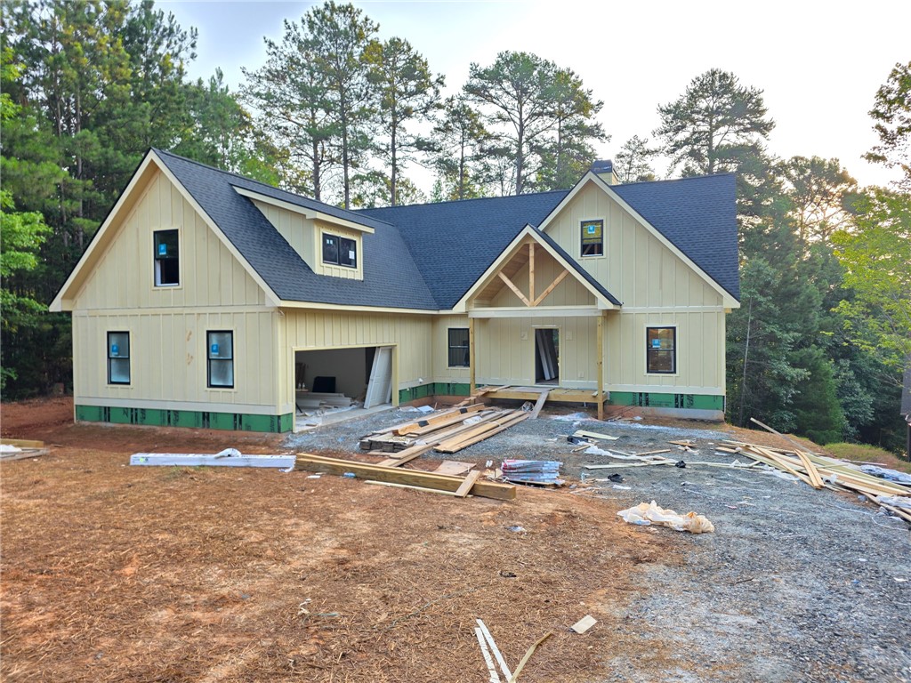 107 Abaco Lane Seneca, SC 29672 - Photo 2 of 28 Newly constructed home features a deep blue roof and natural siding amidst a wooded backdrop.