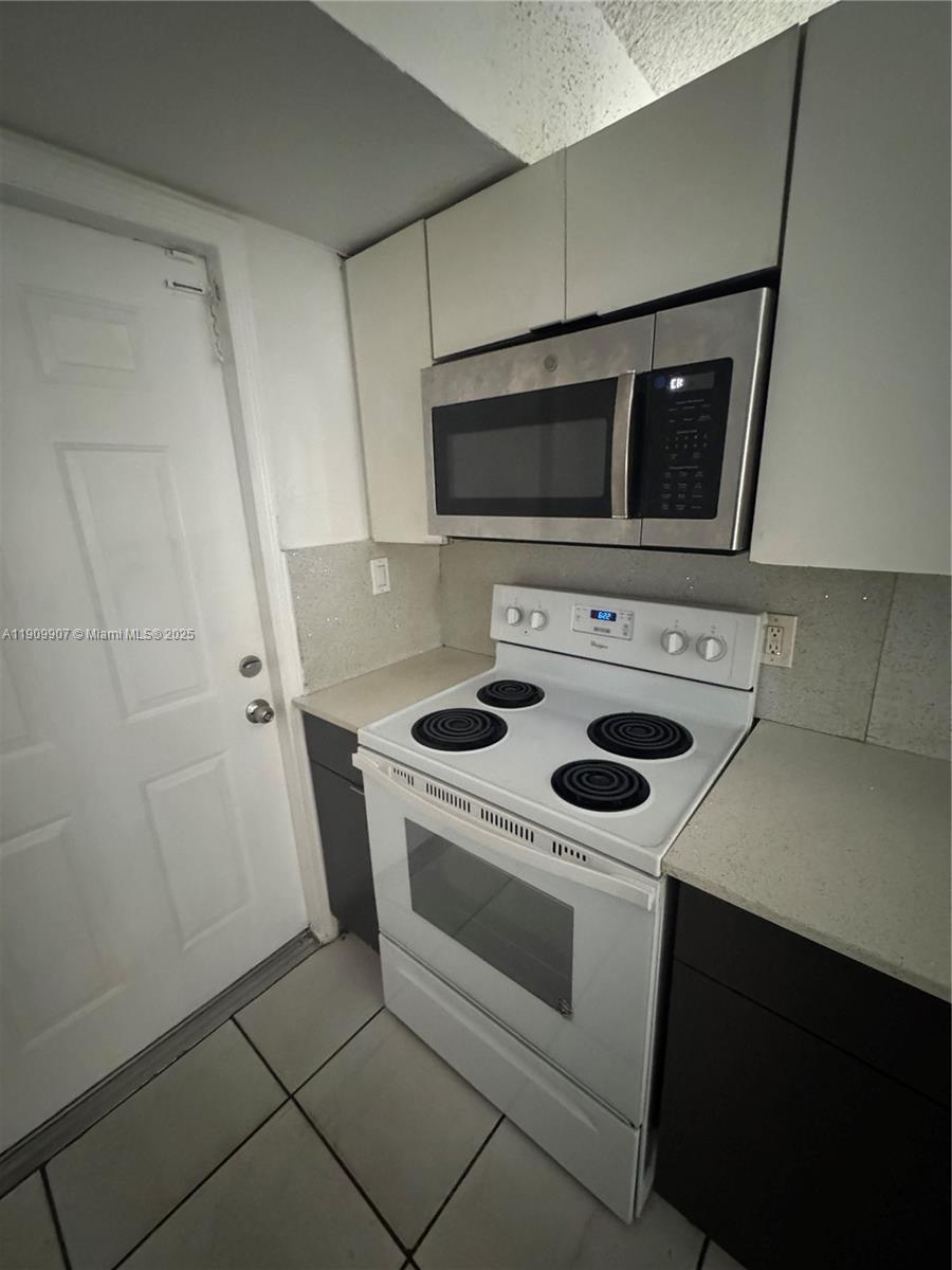 20769 Northwest 41st Avenue Miami Gardens, FL 33055 - Photo 10 of 19 a kitchen with a stove and a microwave