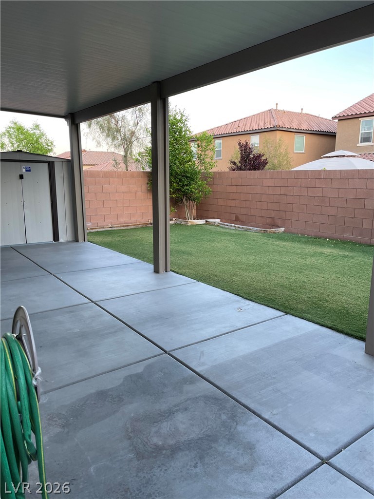 9325 Keystone Ridge Avenue Las Vegas, NV 89148 - Photo 14 of 17 A spacious covered patio offers a comfortable retreat overlooking a vibrant green lawn.