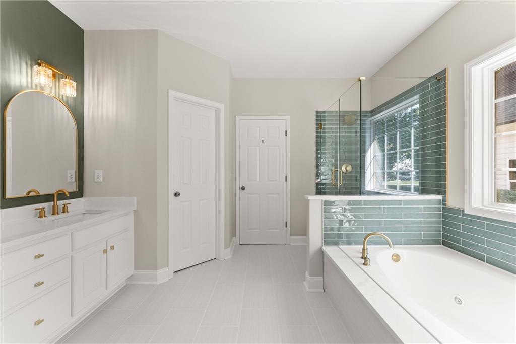 41 Doster Crest Road Jefferson, GA 30549 - Photo 27 of 56 a bathroom with a tub a double vanity sink a window and a mirror