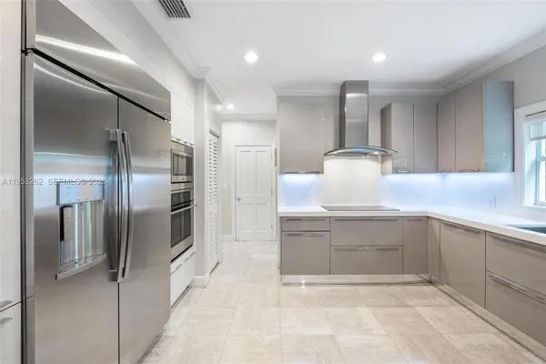 a kitchen with stainless steel appliances kitchen island granite countertop a refrigerator and a sink